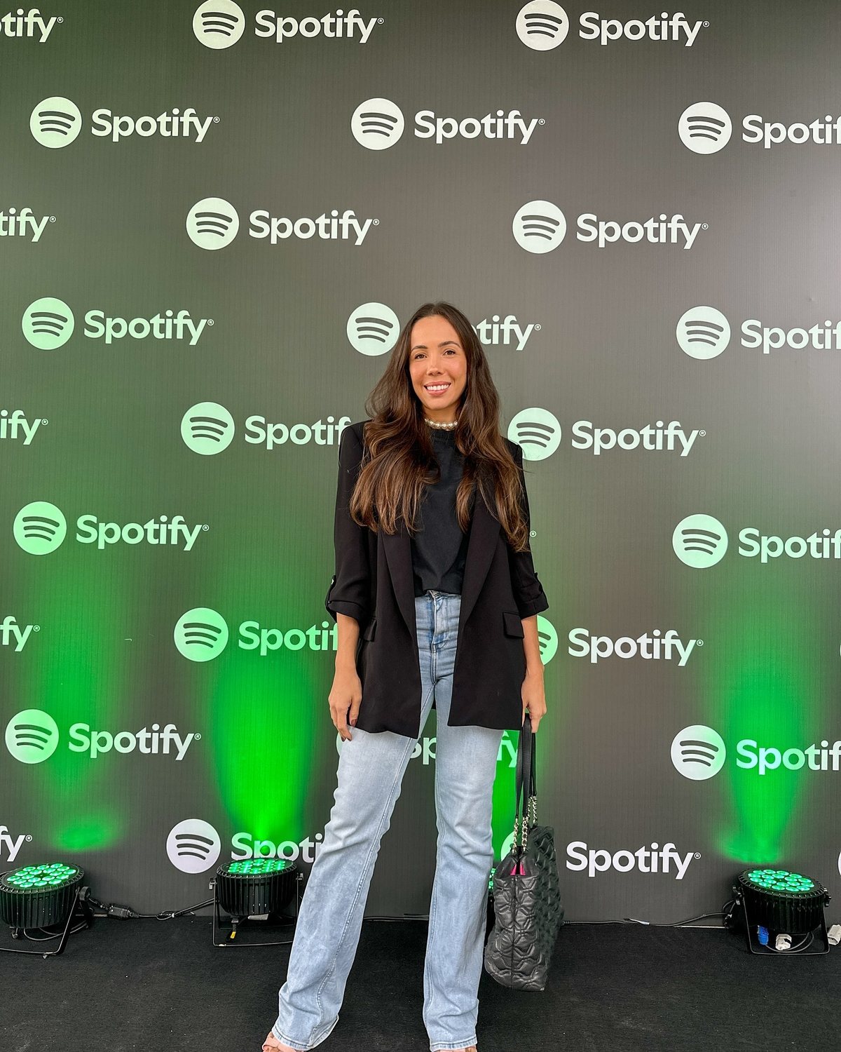Diante do painel da Spotify, em ação de marca de um evento de música