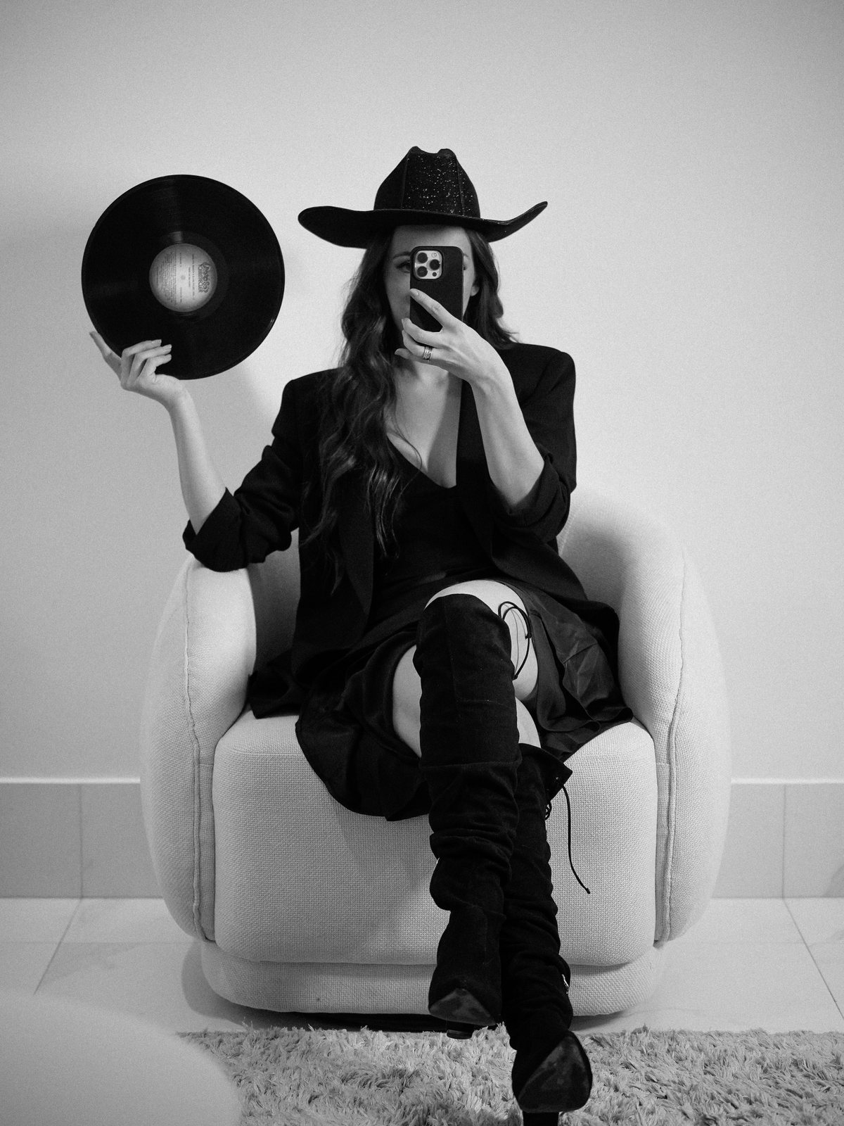 Retrato de estúdio em preto e branco, de chapéu e com um disco de vinil