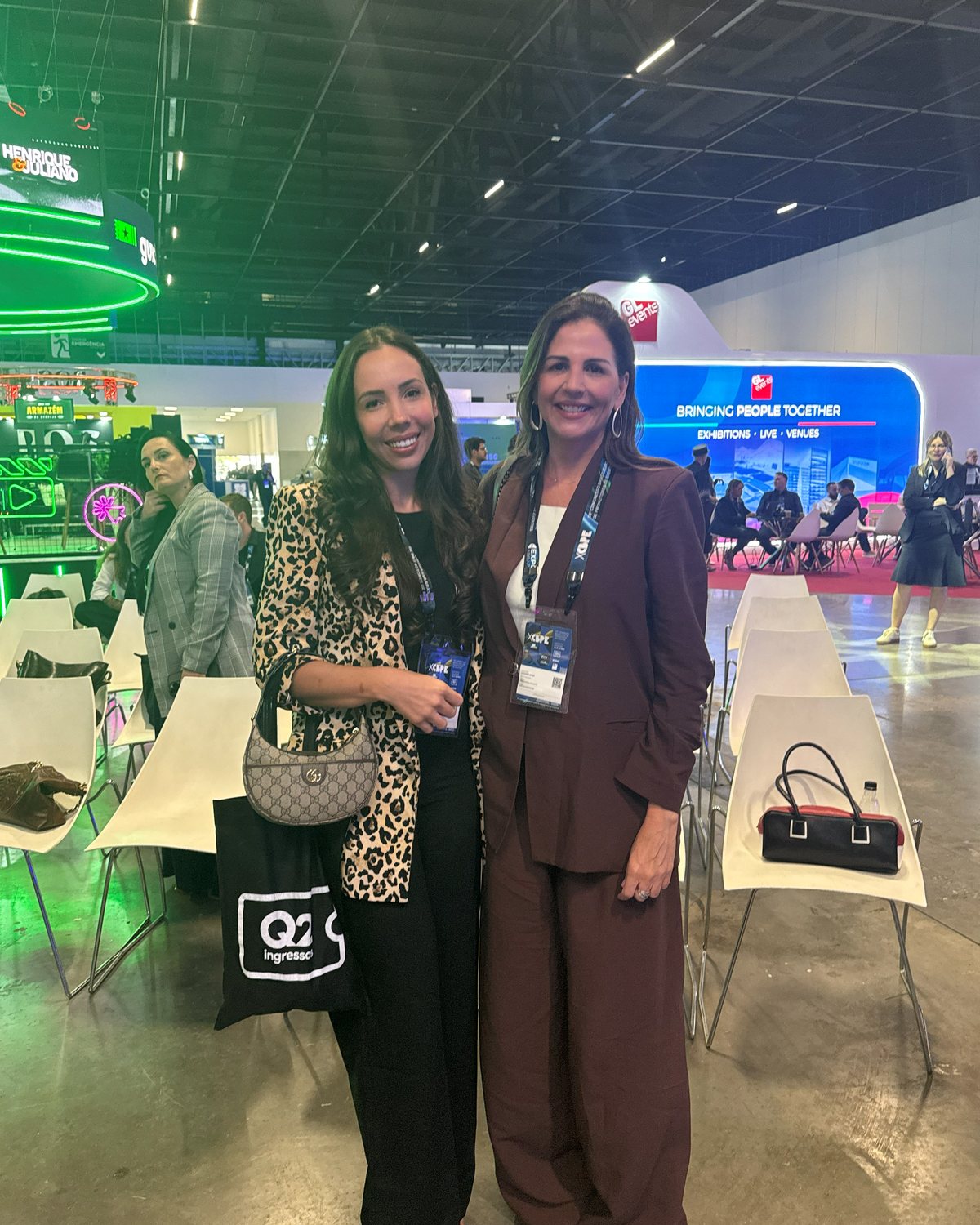 Na feira do setor de eventos, entre estandes, com uma colega do mercado